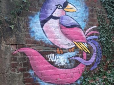 Oiseau colore sur brique — Street art à Saint-Étienne-du-Vauvray