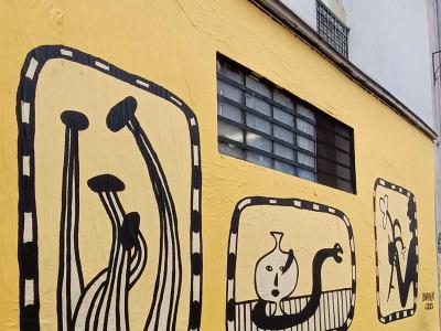 Figures en cadres sur fond jaune — Street art à Paris