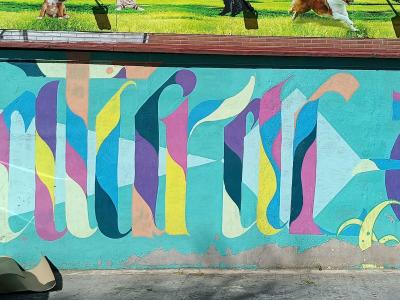Lettrage calligraphique multicolore sur turquoise — Street art à Madrid
