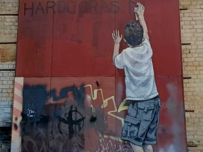 Teenager with hands raised by Zacharevic — Street art by Ernest Zacharevic in Vilnius