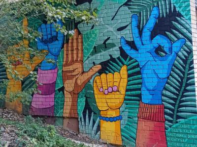 Colorful hands on turquoise background — Street art in Vilnius
