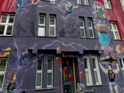 Façade violette aux figures flottantes — Street art à Düsseldorf