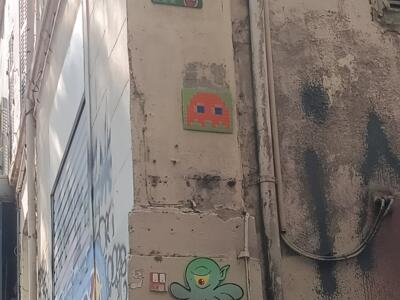 Column of paste-ups on Cours Julien — Street art by Invader, A2, Gzup, Oré in Marseille