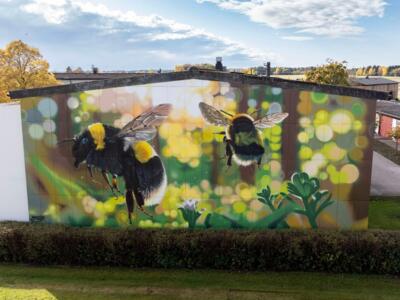 Two bumblebees in a glowing meadow — Street art by Huge in Brålanda