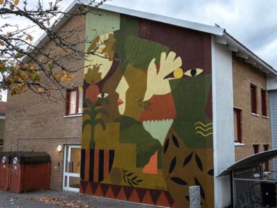 Stylized faces among foliage — Street art by Madi in Vänersborg