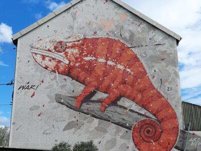 Caméléon rouge sur pignon de maison — Street art de War à Le Mans