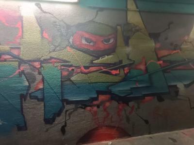 Red Ninja Emerging from Cracked Wall — Street art in Prague