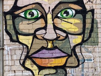Camouflage Face with Green Eyes — Street art in Vilnius