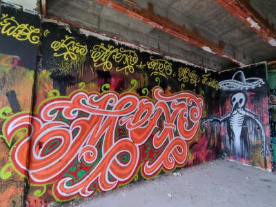 Orange Lettering and Skeleton in a Sombrero — Street art in Grenoble