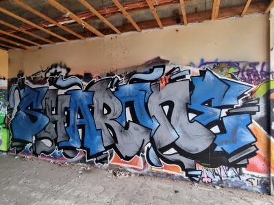 Blue and grey lettering under the slab — Street art in Grenoble