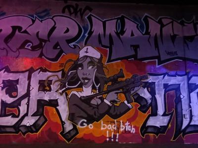 Graffiti wild style avec personnage féminin armé — Street art à Paris