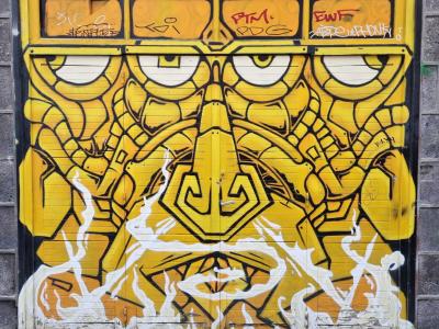 Masque géométrique jaune et noir — Street art à Clermont-Ferrand