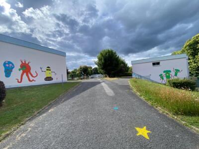 Robots and Aliens between Two Buildings — Street art by Frob in Guéret