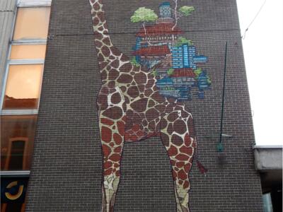 La girafe qui porte une ville — Street art de Psoman à Liège