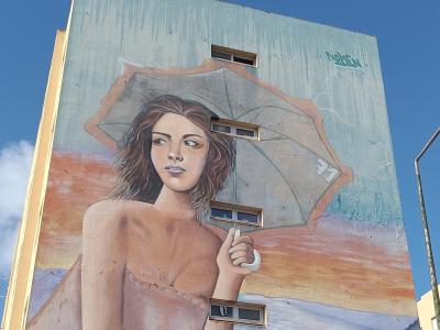 Femme à l'ombrelle sur fond de paysage — Street art de Nomen à Lisbon