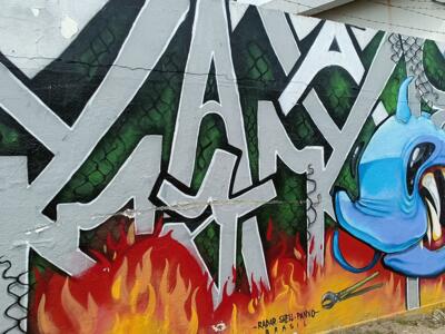 Silver Lettering over Flames with Blue Creature — Street art in Almada