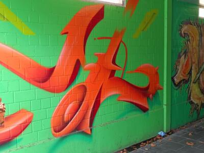 Orange lettering and a small Buddha — Street art by NEANDERARTgroup in Erkrath