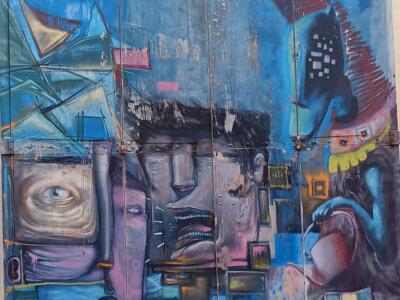 Interlocking Faces on a Blue Door — Street art in Marseille