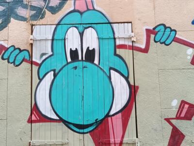 Yoshi turquoise sur porte de bois — Street art à Marseille
