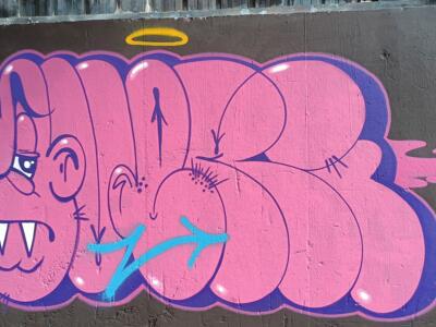 Lettrage rose et personnage à crocs — Street art à Plérin