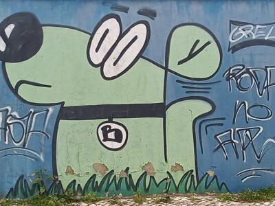 Green dog in painted grass — Street art in Lisboa