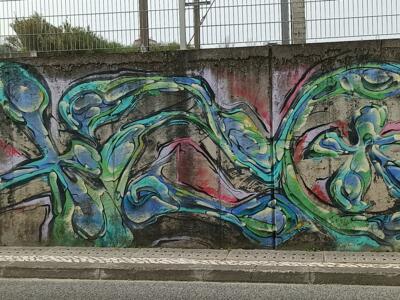 Fluid Green and Blue Lettering on Raw Concrete — Street art by Obit in Lisboa