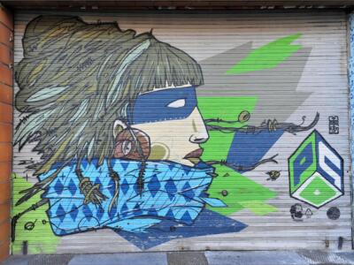 Visage masqué sur le rideau de fer — Street art de Psoman à Liège