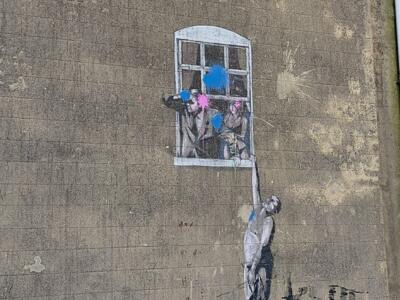 Well Hung Lover, the man hanging from the window — Street art by Banksy in Bristol