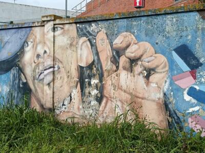 Capped face and clenched fist — Street art in Lisboa