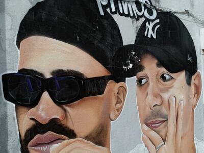 Os Primos, Double Portrait with Caps — Street art by Tempero Diabetico in Almada
