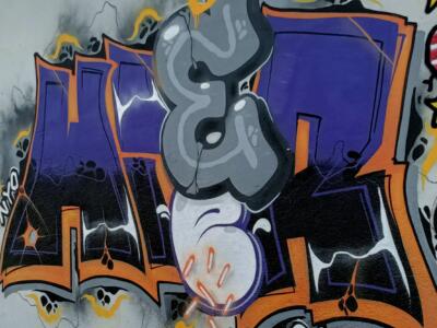 Lettrage violet et orange à la boule blanche — Street art à Almada