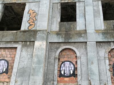 Three Faces in the Bricked-Up Openings — Street art in Almada