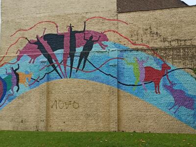 Cave-art arch with colourful figures — Street art in Anderlecht