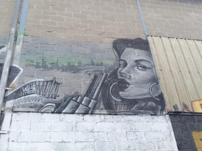 Femme aux créoles et skyline en gris — Street art à Reims