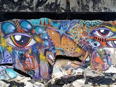 Fresque aux yeux multiples sur dalle effondrée — Street art à Lisboa