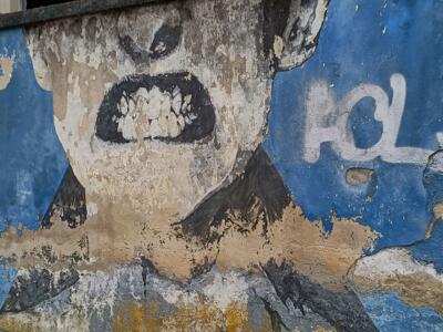 Toothless scream on a ruined wall — Street art in Lisboa