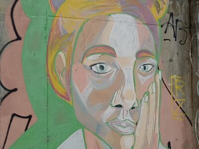 Young Woman with a Bun, Hand on Cheek — Street art in Lisboa