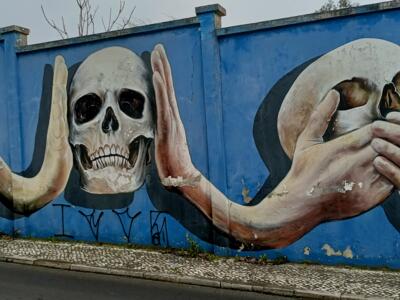 Hands holding skulls — Street art in Lisboa