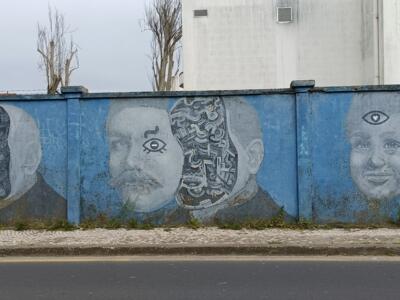 Three faces unravelling into machinery — Street art in Lisboa