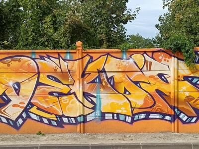 Lettrage orange et or aux notes de musique — Street art à Reims