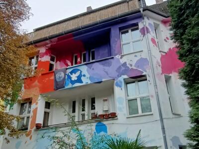 World in Peace, la façade éclaboussée d'Amione — Street art de Amione à Düsseldorf