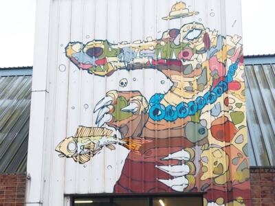 The hatted creature and the fish — Street art by Psoman in Liège