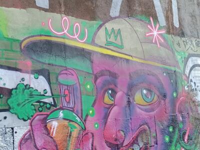 Purple Face with a Cap and Green Spray Can — Street art in Lisboa