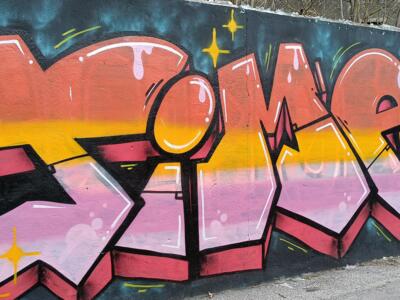 Orange and Pink Lettering with Blue Cap Man — Street art in Almada