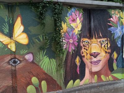 Capybara and woman with jaguar face paint — Street art by Mariana Betancur in Ixelles