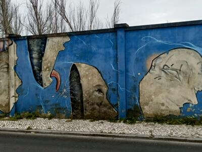 Faces under torn concrete — Street art in Lisboa
