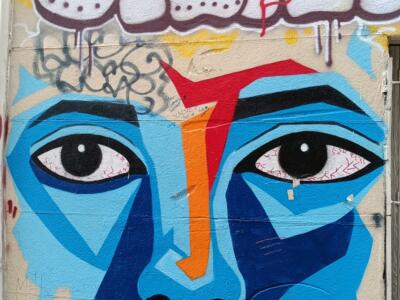 Blue face in geometric facets — Street art in Marseille