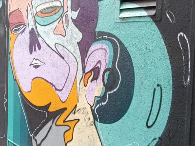 Cubist face on a black wall — Street art in Köln