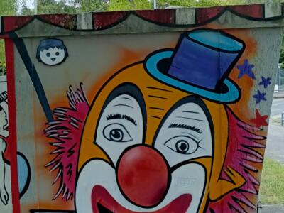 Clown in a blue top hat — Street art in Yffiniac