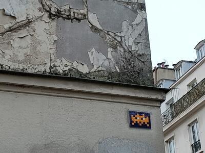 Orange Invader on midnight-blue tiles — Street art by Invader in Paris